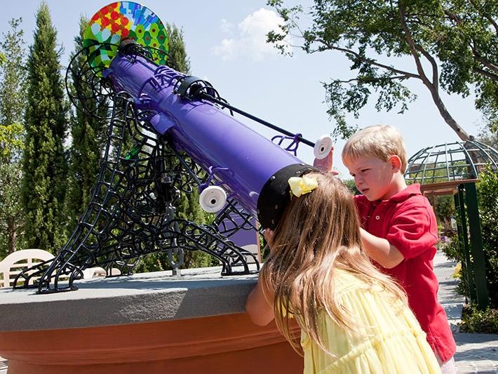 Children outdoors looking through a giant kaleidoscope